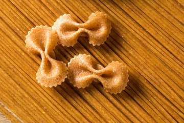 Top view of uncooked pasta integral on a wooden background