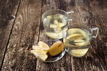Detox water with lemon and ginger in two glass cups.