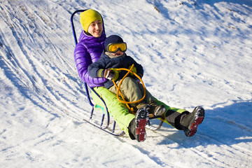 A mom with a child sledding.