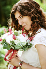 Young smiling bride with wedding flowers