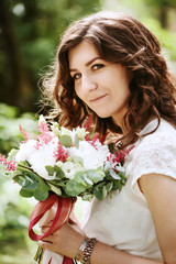 Young smiling bride with wedding flowers