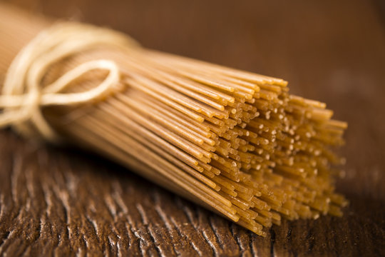 Yellow long spaghetti integral on a rustic background. Yellow it