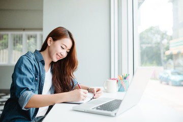 Fototapeta premium indoor picture of smiling Asia woman with notebook and pen