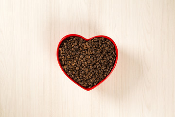 Coffee love concept. Coffee beans in heart into the bown