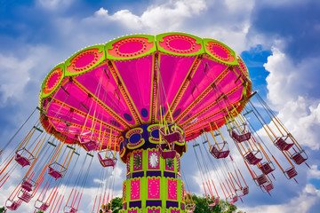 Colorful flying swing ride in motion at the amusement park