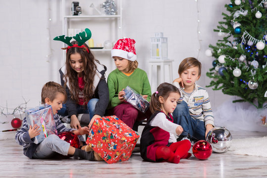 Bambini che aprono i regali di Natale Stock Photo | Adobe Stock