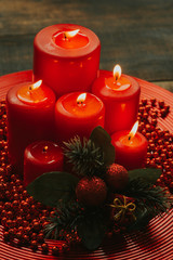 Lighted candles with red colored pearls around
