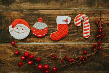 Red cookies for Christmas and a branch with red berries