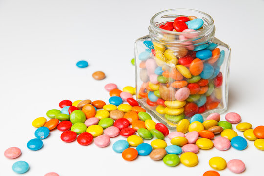 glass jar with colorful candy scattered on the boards. festive background for your design.