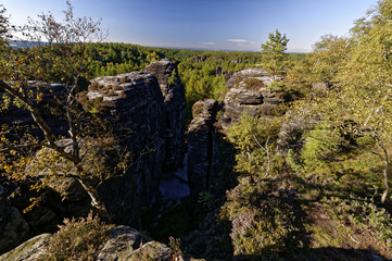 A hollow space in the cntre of tall rock formations surrounded by greenery
