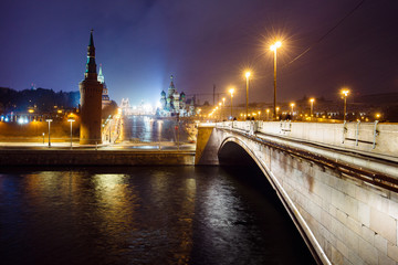 Obraz premium Night cityscape view of Moscow Kremlin, Basil's Descent and Red Square, embankment, strret light at evening winter snowfall from Bolshoy Moskvoretsky Bridge in Moscow, Russia. Long exposure.