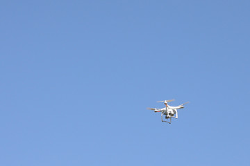 white drone hovering in the sky