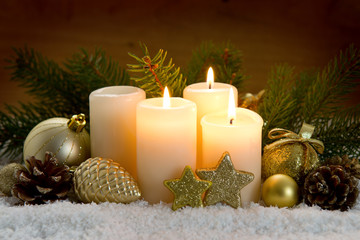 Three burning advent candles and Christmas decoration.