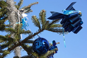 Boule de Noël et ruban bleus sur sapin vert