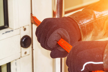 Burglar wearing leather coat breaking in a house