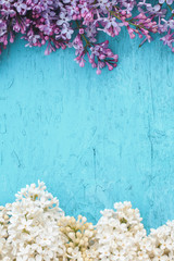 blue wooden background with frame of flowers of lilac