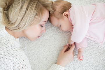 Obraz na płótnie Canvas mother puts her baby daughter to sleep