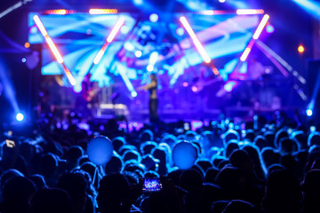 silhouettes of concert crowd in front of bright stage lights