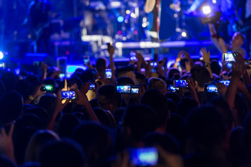 Fototapeta premium Hand with a smartphone records live music festiva