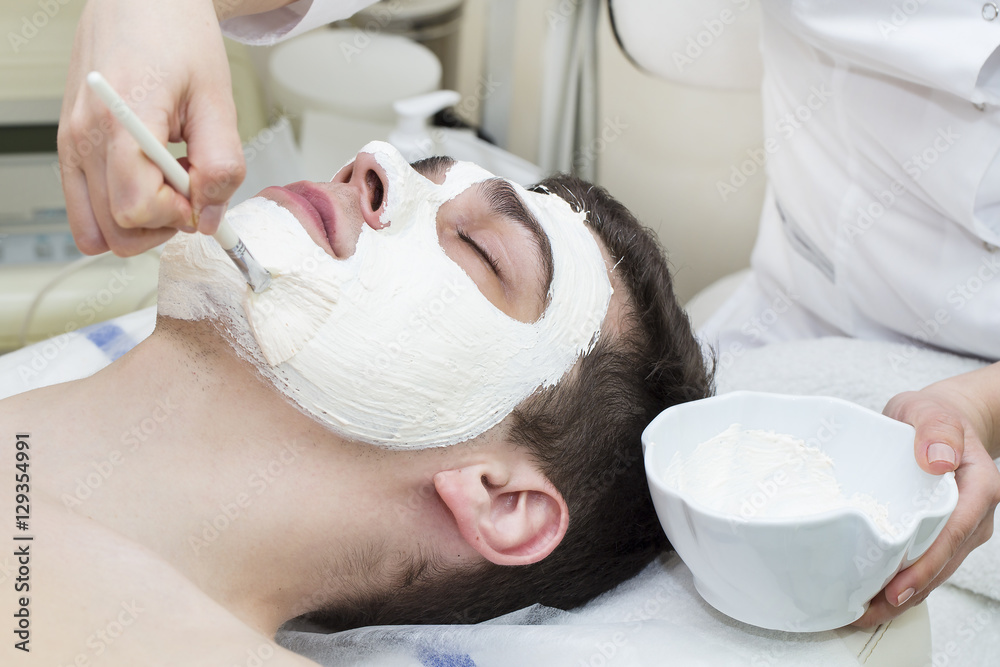 Wall mural man in the mask cosmetic procedure in spa salon