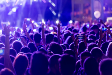Obraz premium Ręka ze smartfonem nagrywa muzykę na żywo festiva