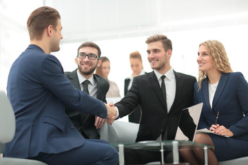 Businessman by handshake invites to cooperation.