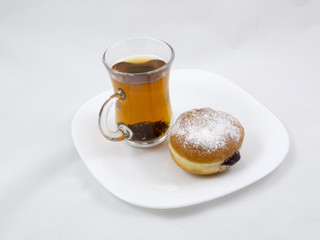 Transparent Cup with Tea and a Donut