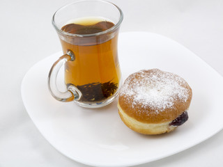 Transparent Cup with Tea and a Donut