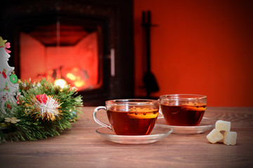 Cup with Christmas ornament near fireplace. Winter holiday concept