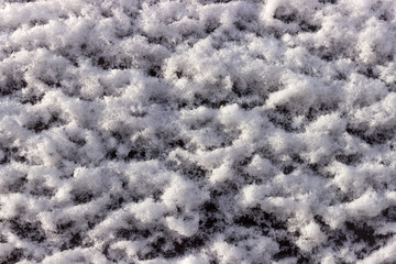 Car window covered with snow.  The build up of snow on the tinte