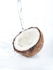 Cracked coconut with water splash isolated on white background