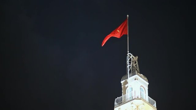 Vietnamese flag on the tower of the city hall in the night Saigon