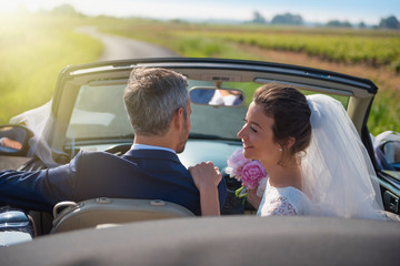 young couple is going on honeymoon  by car on a country road