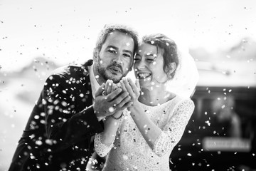 portrait of beautyful newlyweds blowing on confetti