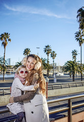 mother and child tourists on embankment in Barcelona hugging