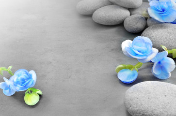 Fototapeta na wymiar Blue flower and stone on grey background