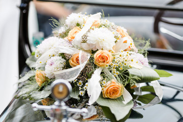 Hochzeitsstrauß auf Oldtimer bei einer Hochzeit