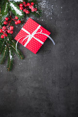 Christmas gift, tree branch, decorations on slate background.