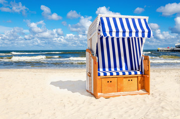 Blue and white wicker chair on sandy beach