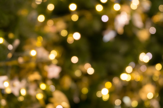 christmas tree bokeh light in green yellow golden color, holiday abstract background, blur defocused
