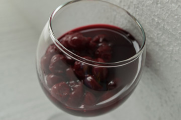 Cherry jam close up of a wine glass on a light background