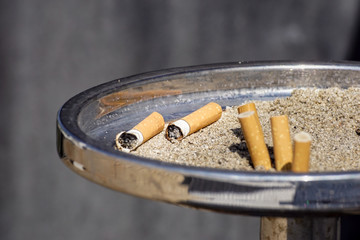 Closeup view of full ashtray on the table.