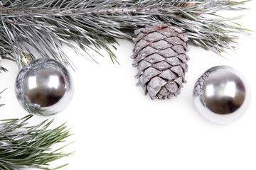 Pine branches with silver cones and balls on white background 
