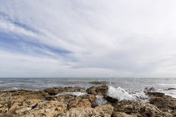 Fototapeta na wymiar Rocky beach with waves in Santa Pola, Alicante province, Spain.