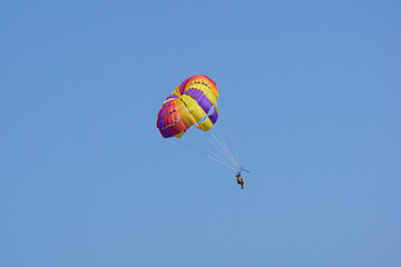 Parasailing is a popular pastime in many resorts around the world. The active form of relaxation. Focus on  parachute.