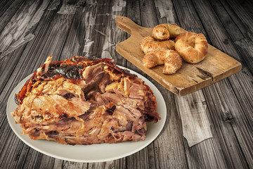 Plateful Of Spit Roasted Pork Ham And Croissant Puff Pastry Cheese Rolls Set On Old Cutting Board Served On Cracked Flaky Wooden Garden Table