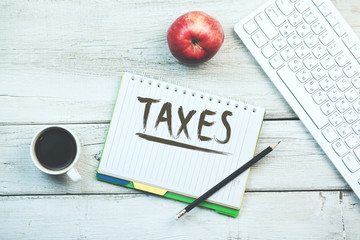 Taxes text on notebook with keyboard