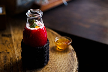 Hot red tea with honey in the bottle with knitted mitten