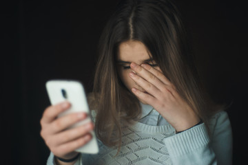 Teen girl excessively sitting at the phone at home. he is a victim of online bullying Stalker...
