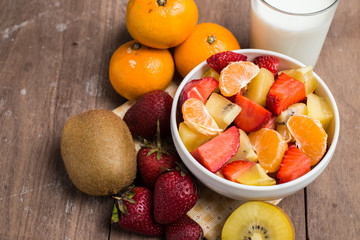 Milk and ftuits salad on the wood background.